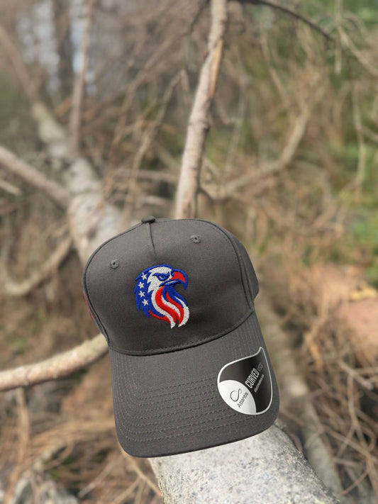 Grey trucker cap with a logo of eagle on a branch against a natural background front view