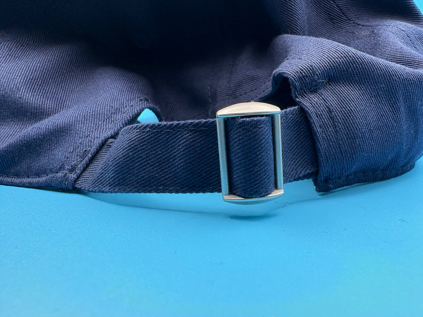blue cap with a metal buckle rear view