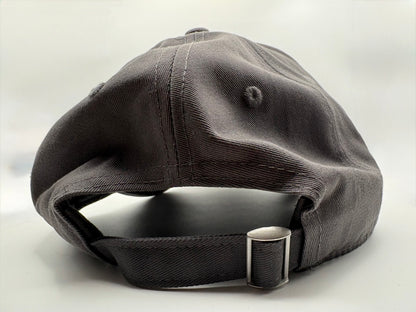 Dark gray cap with a metal buckle on a light gray background  rear view.