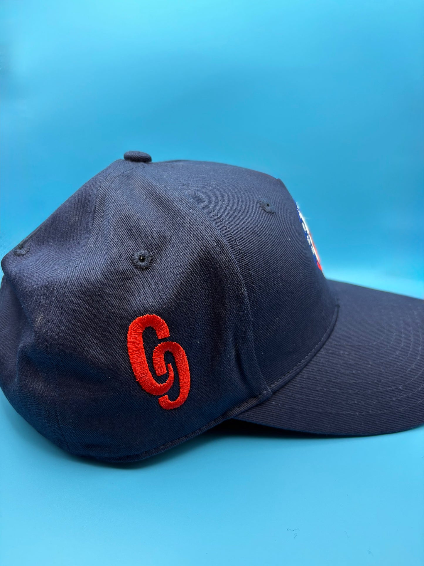 Navy blue cap with red logo trucker cap CG side view